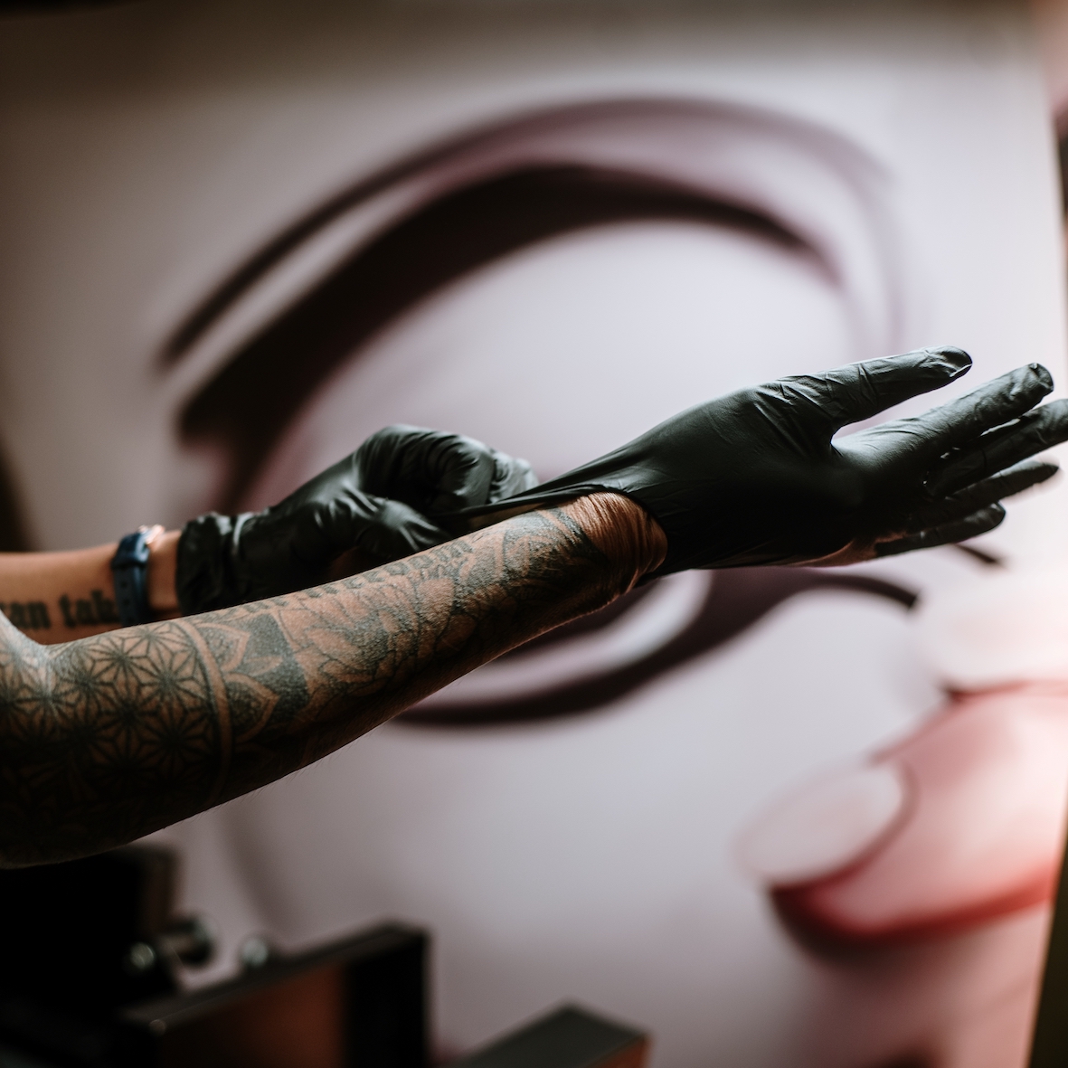 a tattoo artist preparing by putting disposable gloves on