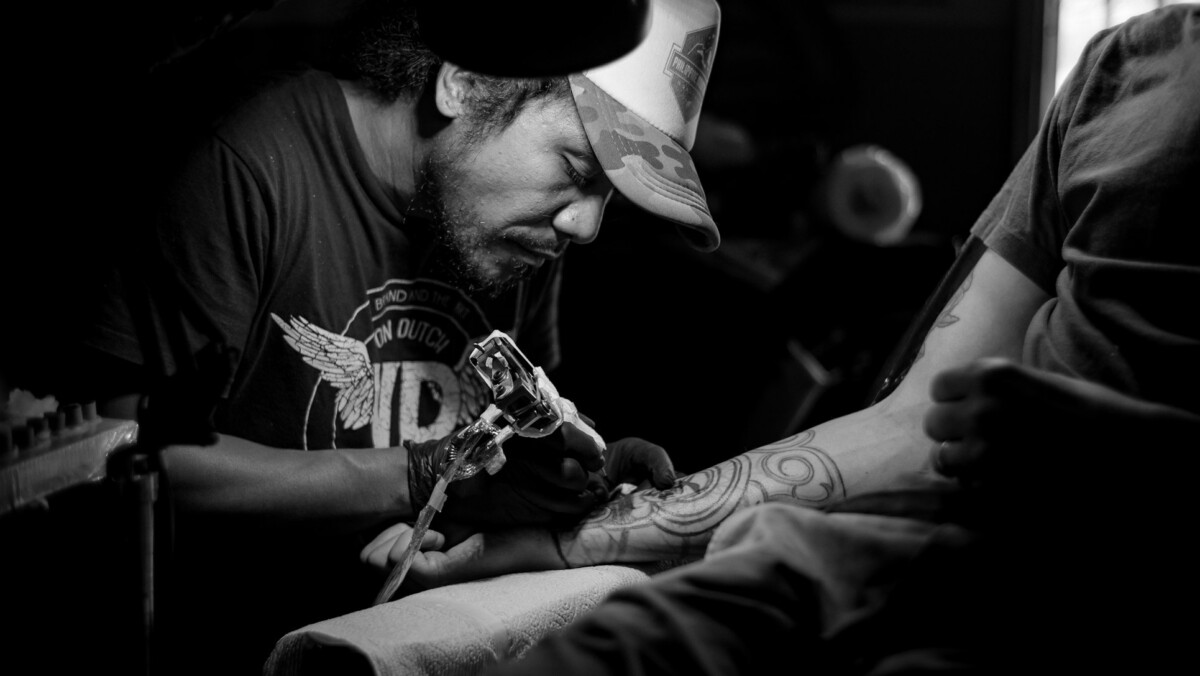 a local tattoo artist form Canggu working on a man's forearm